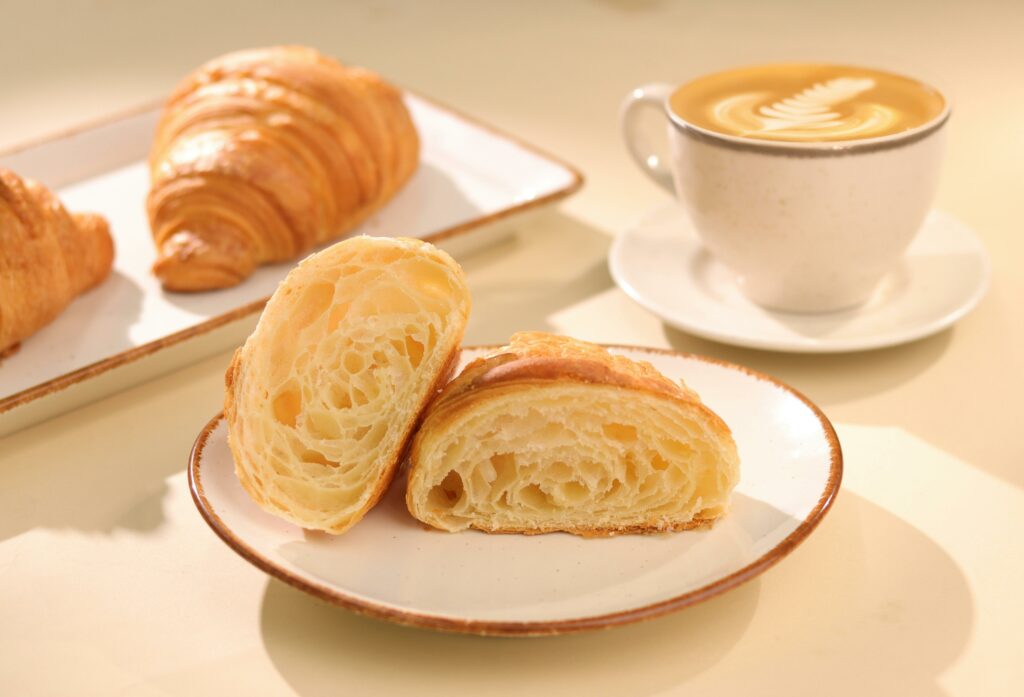 Delicious croissant accompanied by a steaming cup of coffee, perfect for a warm breakfast in Mumbai.
